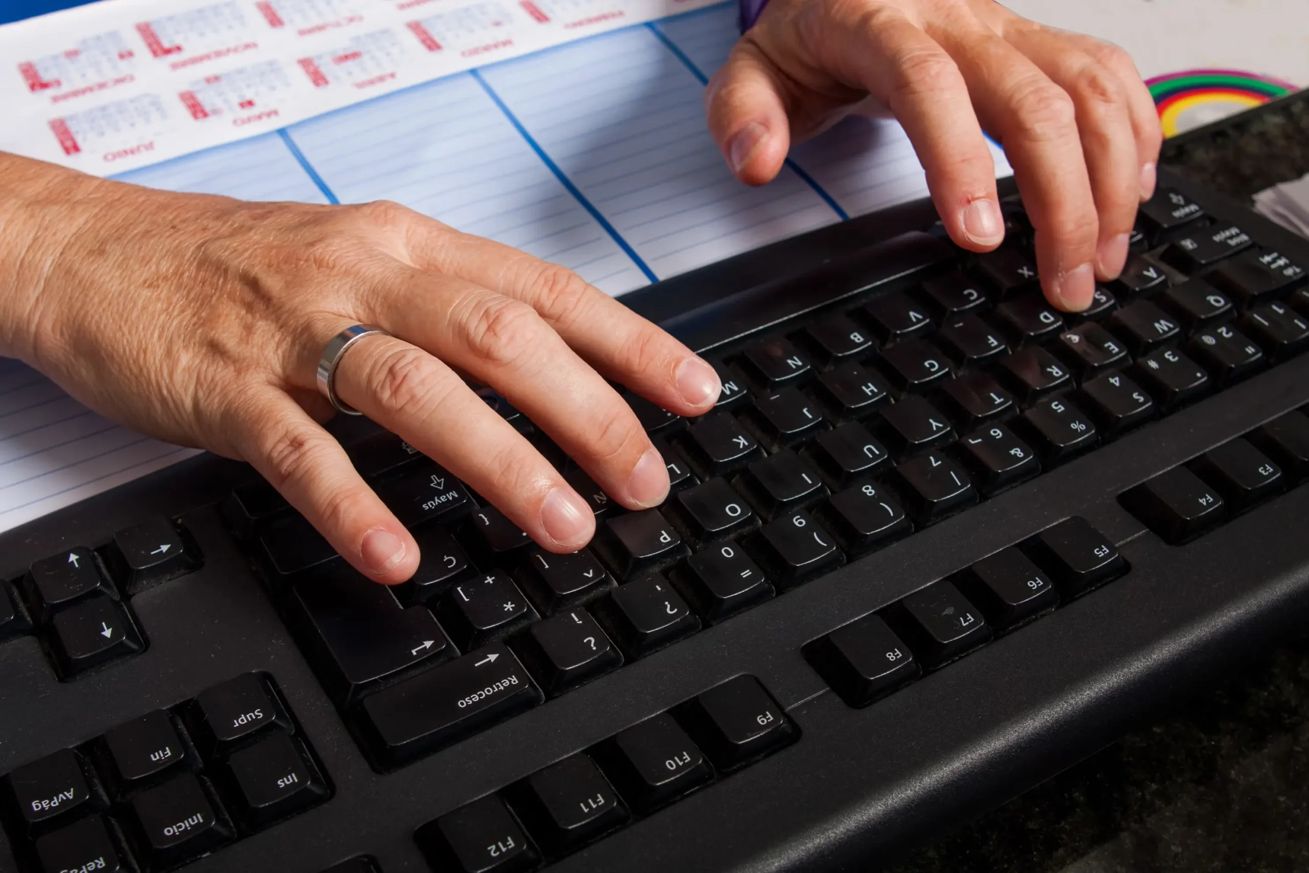 Close up of hands typing on a computer keyboard