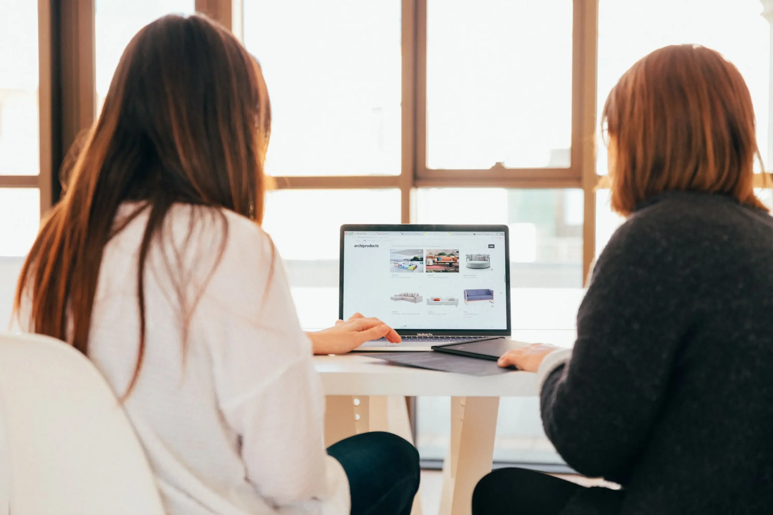 An image of two individuals looking at a computer screen